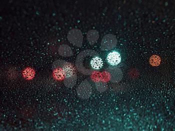 raindrops on the glass on blur background of colored spots