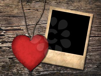 red paper heart and old photo  on the wooden background