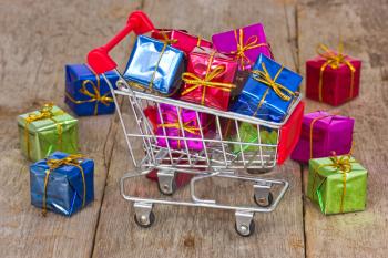 Holiday sale and shopping concept. Cart with colorful gift boxes.