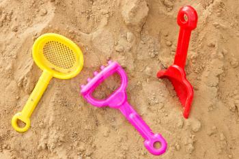 set of color plastic toys on a sand