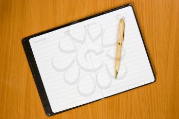 White open notebook and pen on the  wooden table