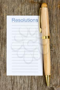 Royalty Free Photo of a Wooden Pen With a List for Resolutions