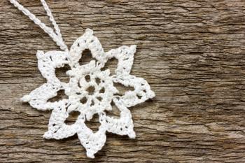 Crochet christmas snowflake  hanging on wooden wall
