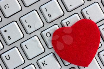 Internet dating concept. Red heart on the computer keyboard.