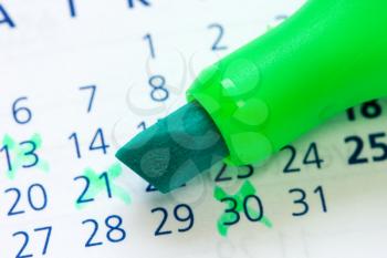 Close up of a calendar and green marker 