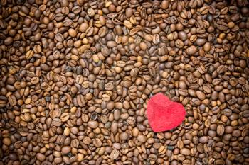 Red heart on coffee beans background, love concept 