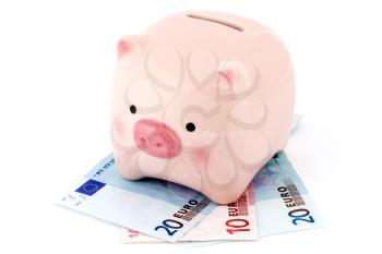 Piggy bank on the Euro banknotes. Isolated over a white background