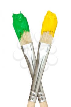 Paint brushes with yellow and green paints. Isolated on white background