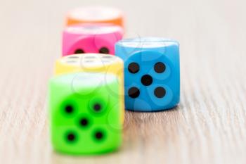 Colorful dice on the wooden surface. Selective focus on blue