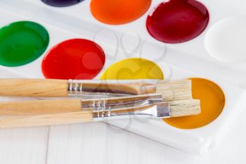 Palette of children's  watercolor paints with paint brushes