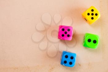 Four color dice on the cardboard background with copy-space