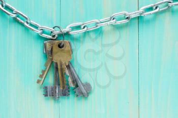 Old keys hanging on blue wooden background