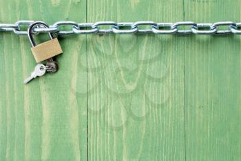 Chain and lock on  green wooden background