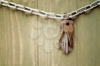 Keys hanging on blue wooden background. Image toned with vintage filter.