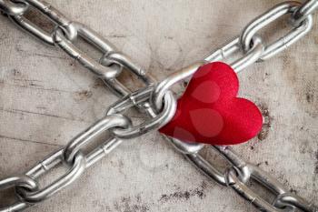Love. Crossed chains with red heart  on dirty background.