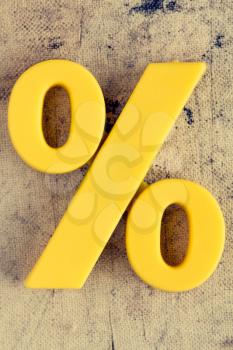 Yellow plastic percentage sign on grunge background