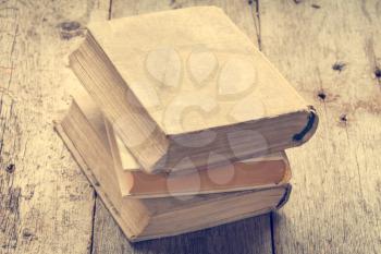 Old books on wooden background in vintage tone color