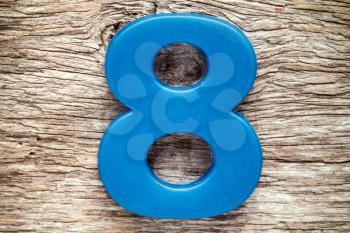 Blue number eight on the wooden background