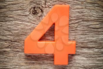 Orange number four on the wooden background