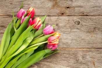   Bunch of beautiful tulip flowers on wooden background background
