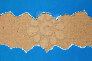  Torn blue paper with a cardboard background for your text.