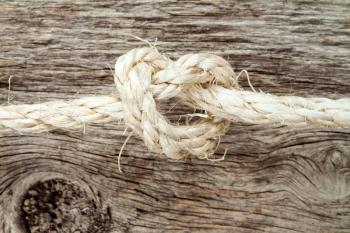 Sisal rope with knot on the wooden background