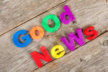   Colored  letter magnets spelling text GOOD NEWS