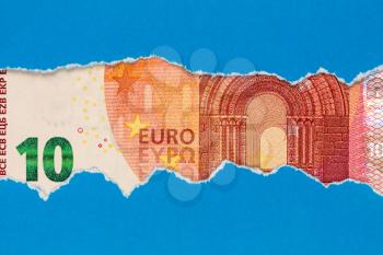 Ten Euro bill in torn blue paper frame