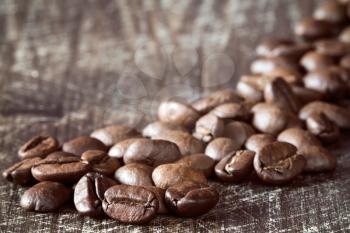 Heap of coffee beans close-up on wooden background