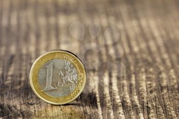 Euro coin on wooden background showing financial investment or savings