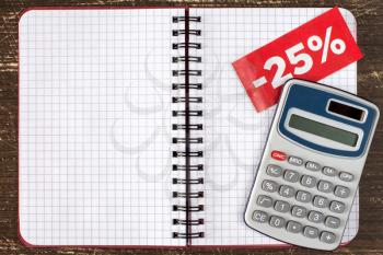 Digital calculator and blank notebook with tag of discount or sale