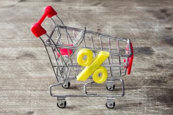 Yellow plastic percentage symbol on shopping cart