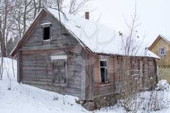 Old abandoned wooden house in a frosty winter 
