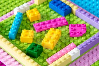 Baseplate with colorful plastic building blocks. Toys background.