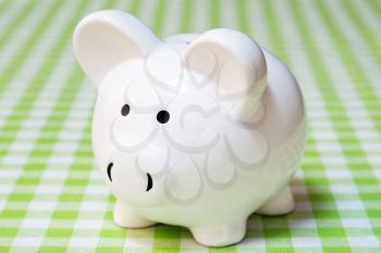  White piggy bank on the table with checkered tablecloth