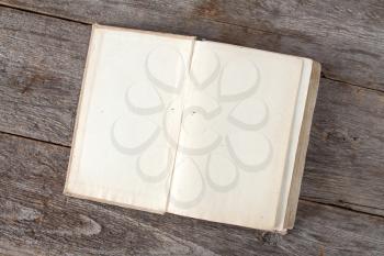 Open vintage book on old wooden background, with copy-space