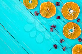  Orange slices and dry herbs on the blue wooden background.