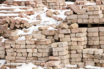 Pile of masonry bricks under the snow