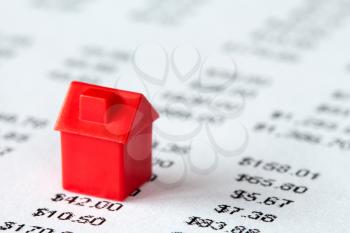 Red miniature house on a financial report background