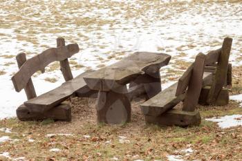 Wooden picnic table with benches in the winter park