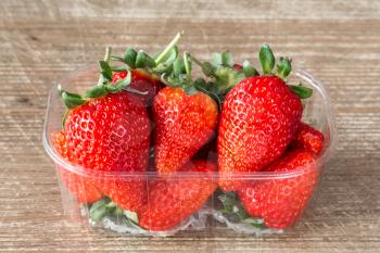 Plastic box full of red fresh strawberries