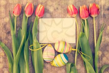 Easter eggs,fresh spring tulips and blank card for copy-space