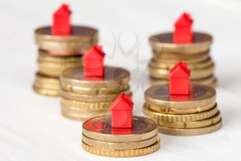  Mini houses and coins stacks. Concept for property ladder, mortgage and real estate investment