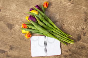 Bunch of spring tulips and blank notebook for copy-space