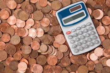 Calculator and heap of euro cent coins of different denominations