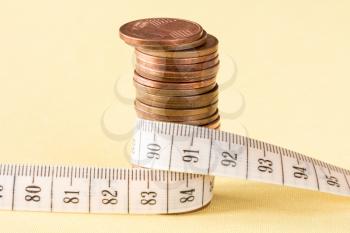 Tight financial budget concept with coins and measurement tape 