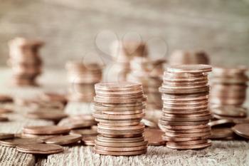 Copper coins stacked on wooden background (Euro cents)