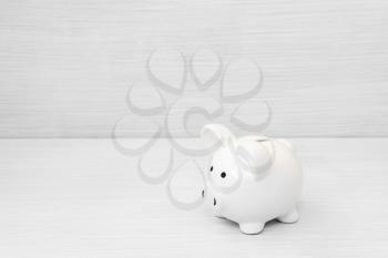Ceramic piggy bank on white wooden background. Business and finance concept