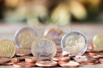 Euro coins. One Euro coin on the foreground. Shallow depth of field
