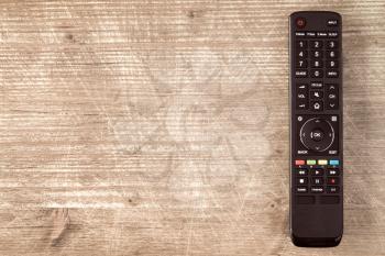 Tv remote controller on wooden background, copy-space